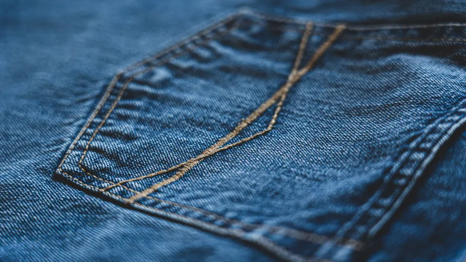Close-up of blue denim jeans showing pocket stitching